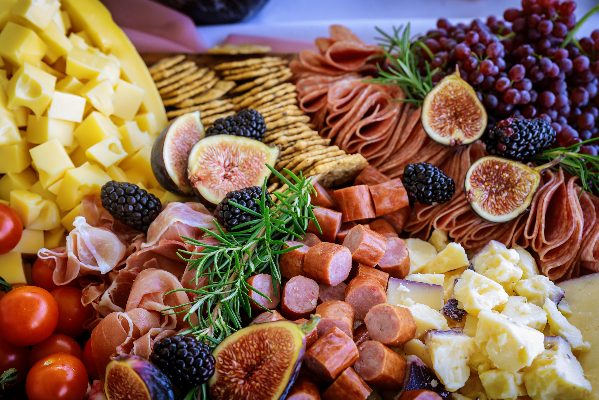 Cheese, fig, and crackers on charcuterie board .