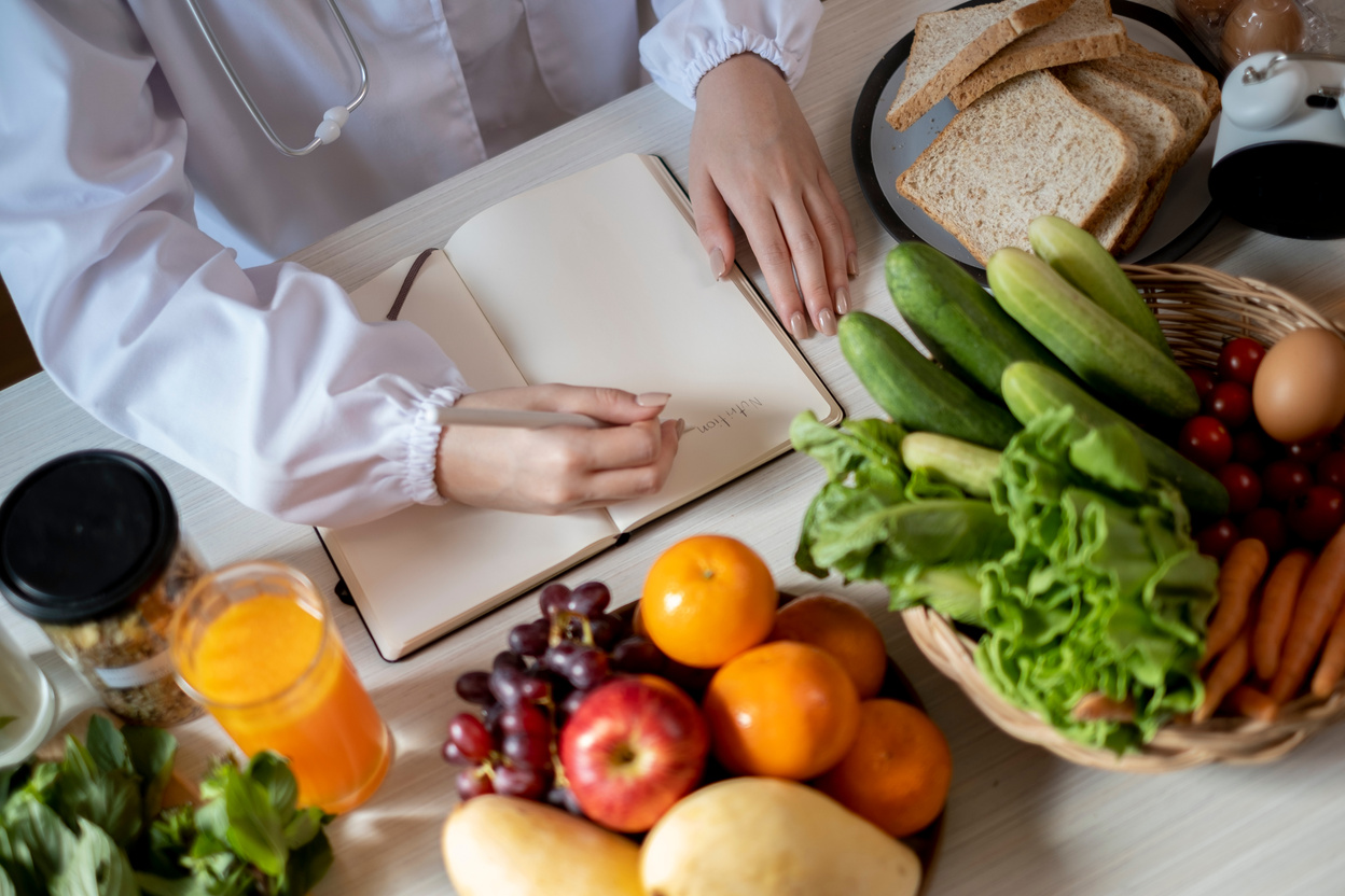 Nutrition consulting with note book and vetgetable background.